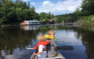 Two kids in a boat on a lake.