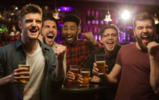 Men at a bar with beers.