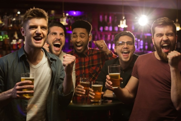 Men at a bar with beers.