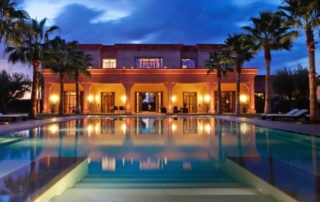 Italian villa with pool and palm trees.