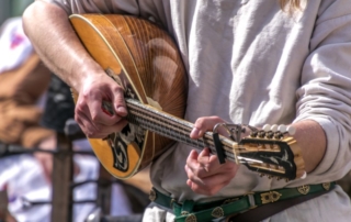 Close up of musician playing a lute.