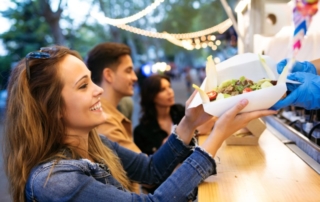 Woman receiving food from a food truck.