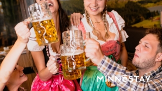 People toasting "PROST" in German attire at Oktoberfest in Minneapolis
